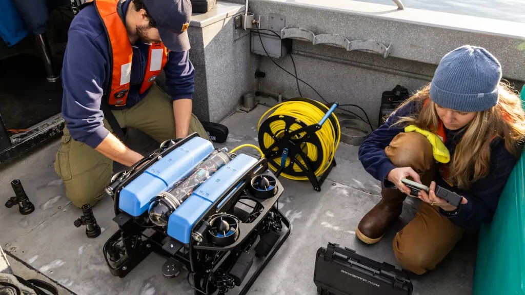 Seattle Aquarium researchers on a boat preparing the Aquarium's underwater ROV for deployment.
