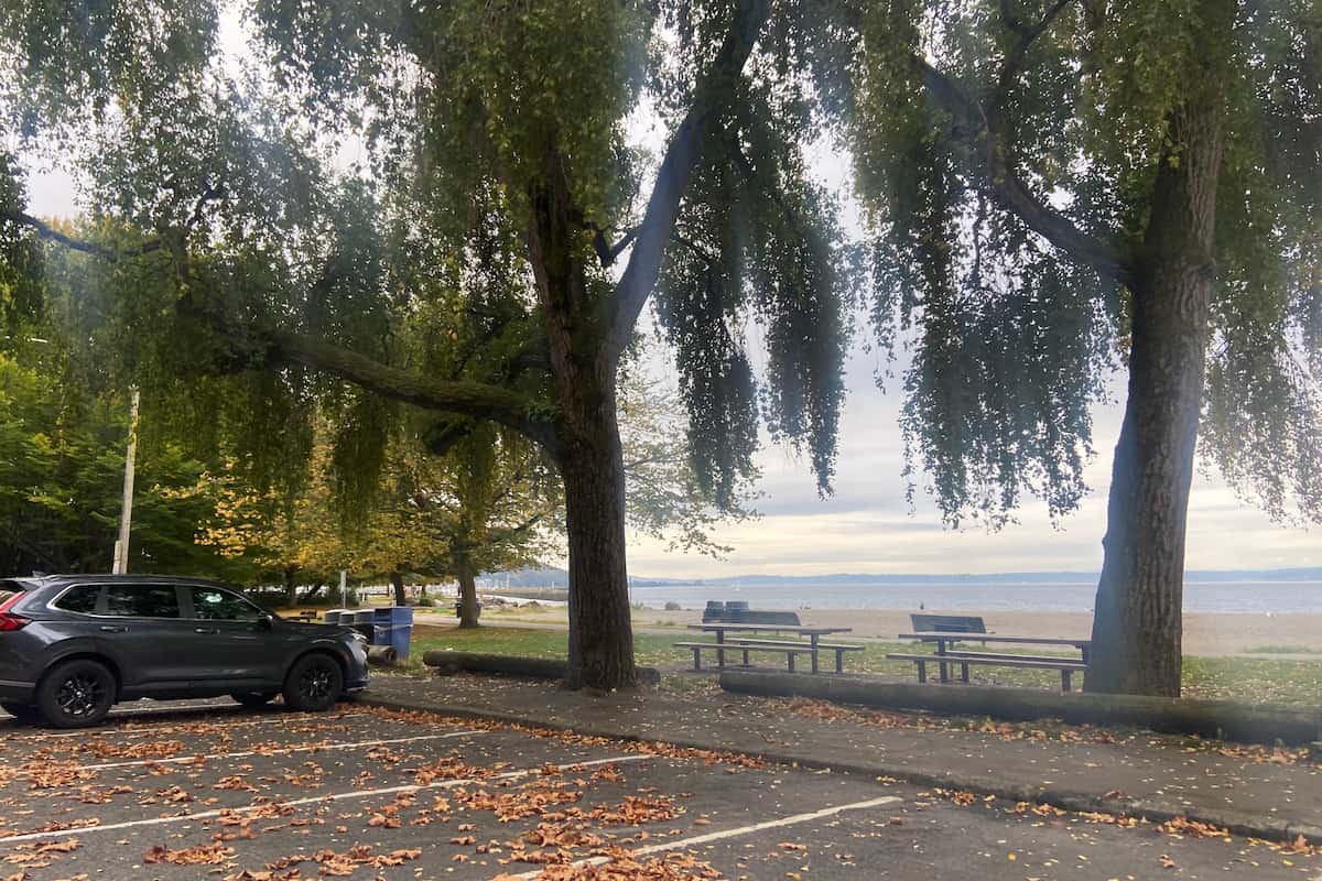 There are many picnic tables along the walking path that runs parallel to the beach.
