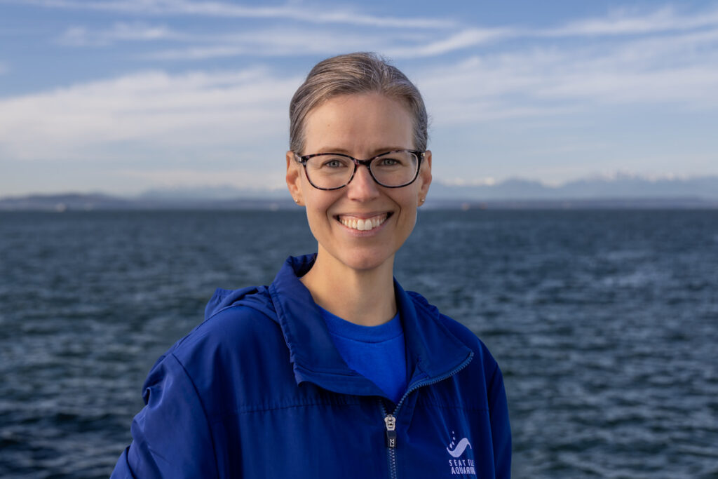 Meg McCann smiling for a profile photo with the waters of Elliot Bay behind her.